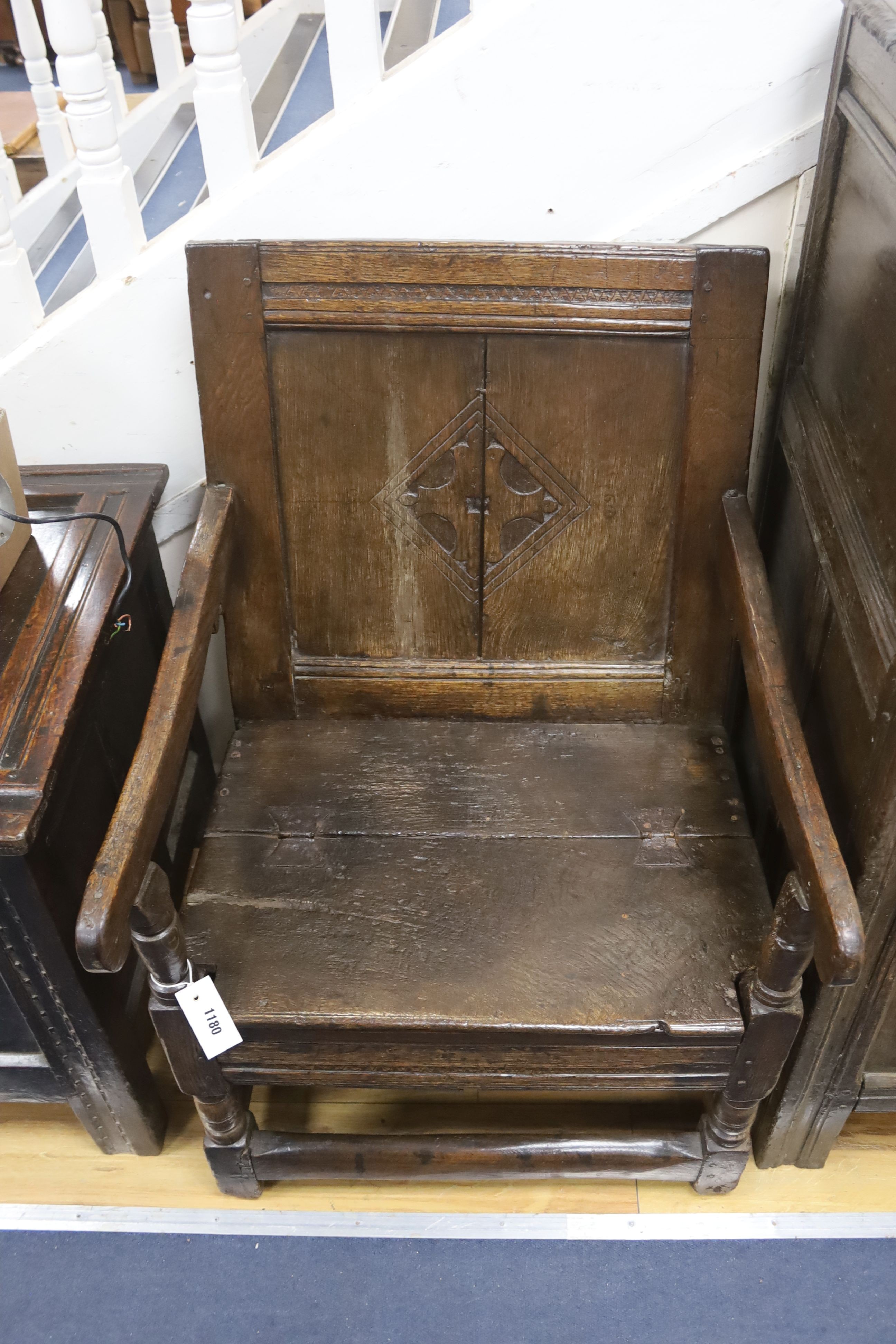 A joined oak merchant’s wainscot box-seated chair, the twin panelled back carved with a stylised cross in diamond device, early-mid 17th century, width 62cm, depth 62cm, height 91cm